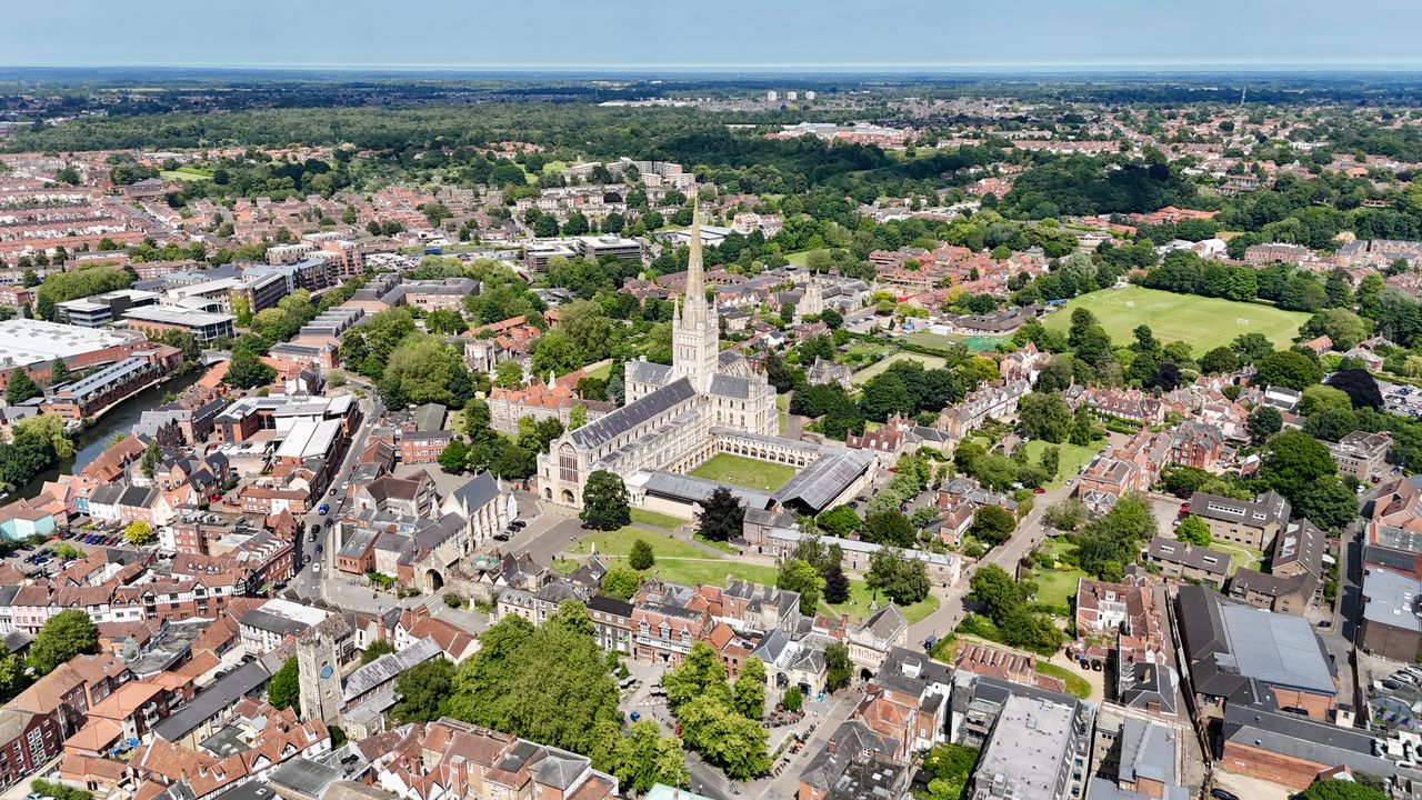 Aerial shot of Norwich Cathedral in Norfolk, showcasing urban and natural landscapes.
